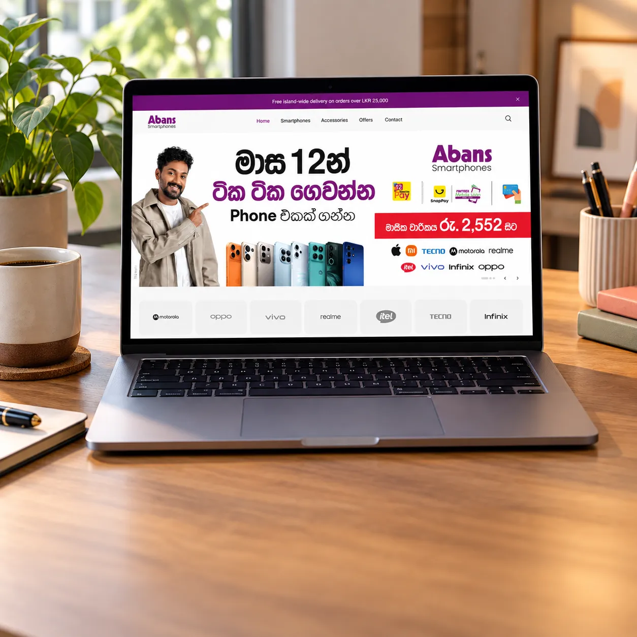 The Abans Smartphones website open on a laptop on a wooden desk